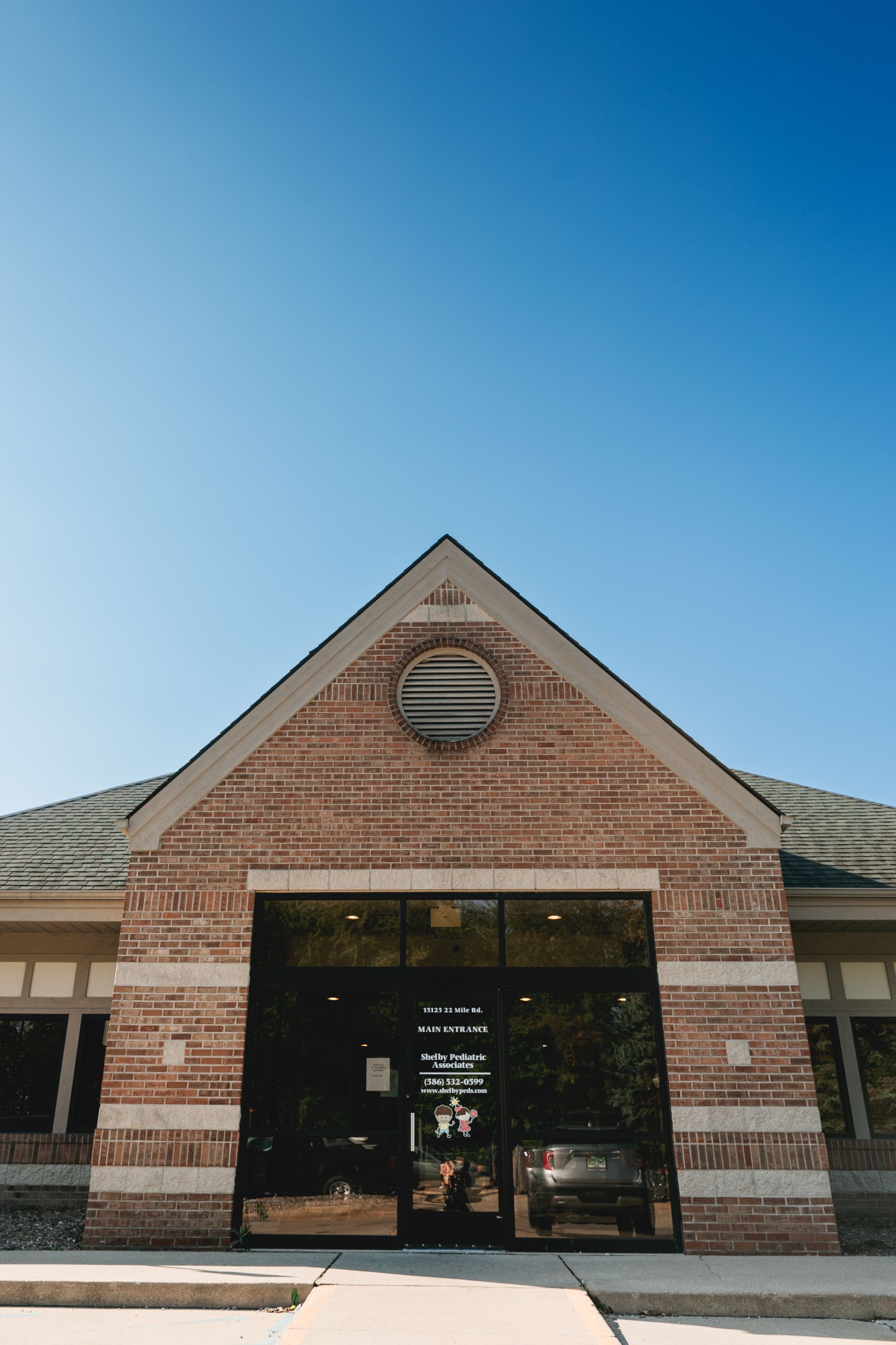 The front of a brick building with a blue sky in the background.