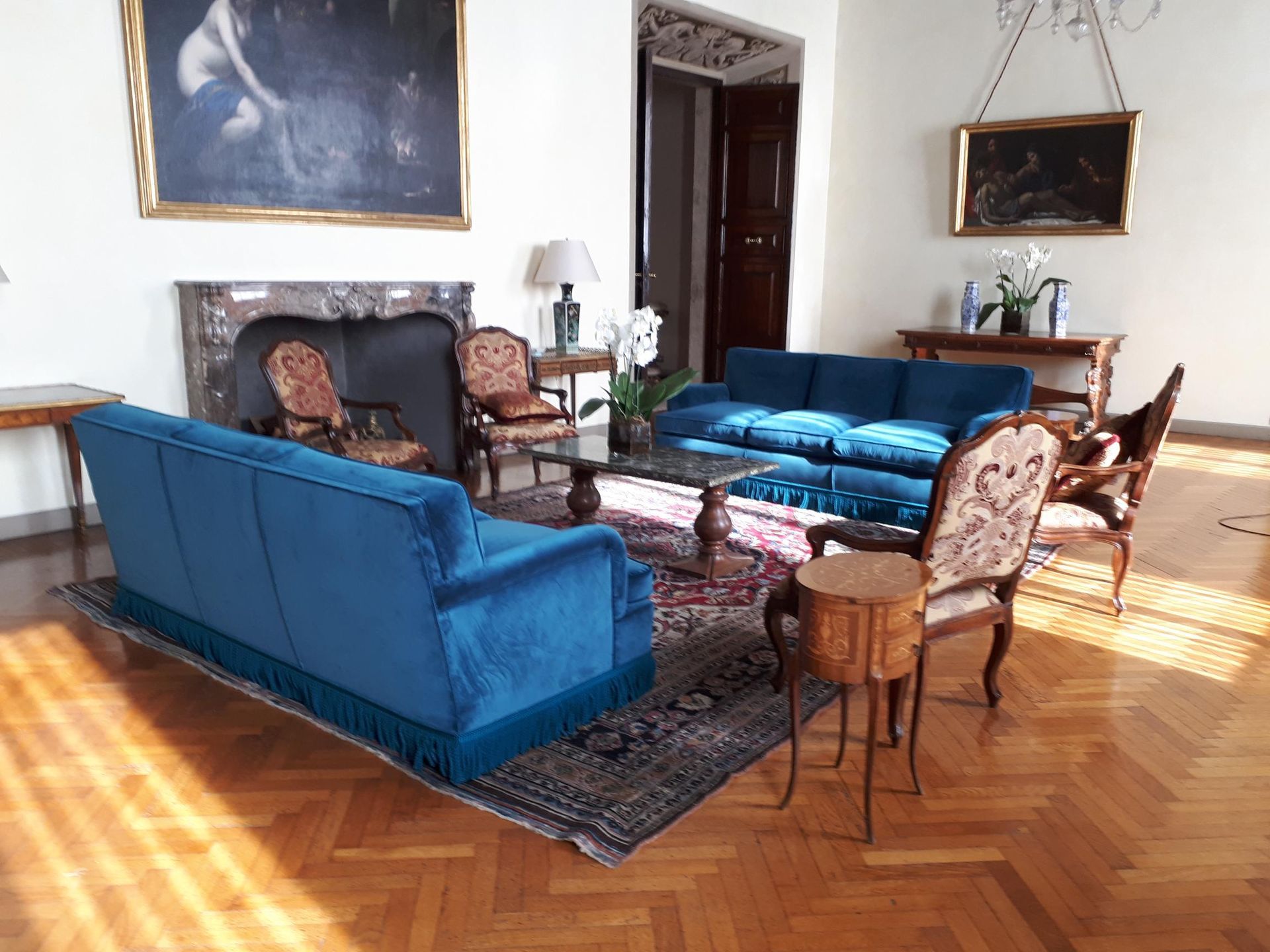 salotto con camino sedie e divani con stoffa blu