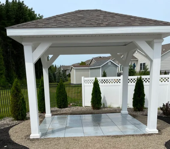 White gazebo with gray tiled floor, in a backyard setting.