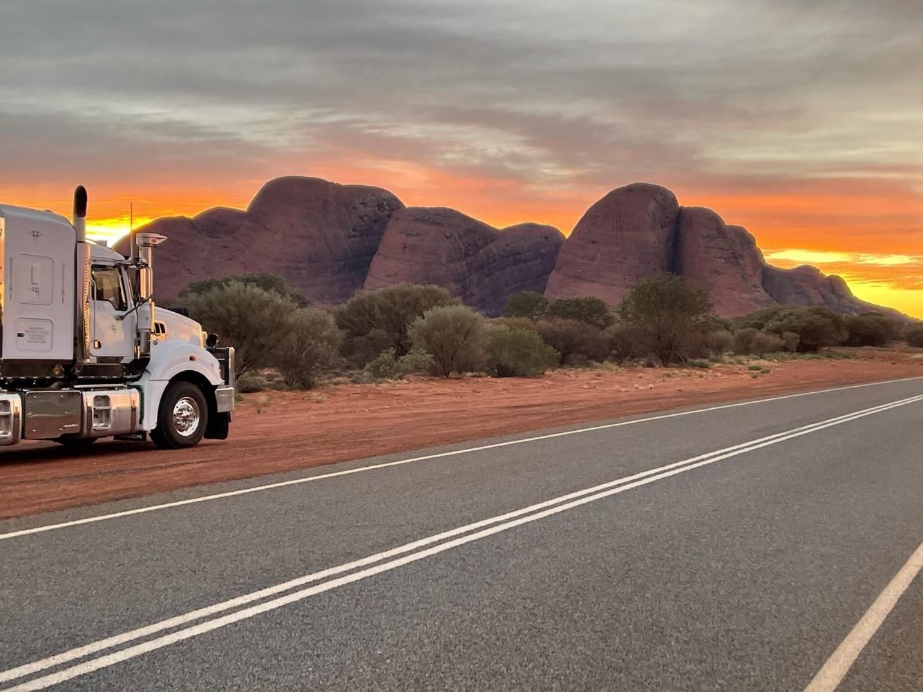 A Truck Is Parked On The Side Of A Road With Mountains In The Background — Willow's Bitumen Haulage Pty Ltd In Northern Territory