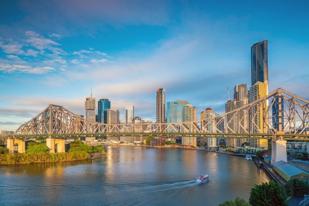 A Bridge Over A River With A City Skyline In The Background — Willow's Bitumen Haulage Pty Ltd In Queensland