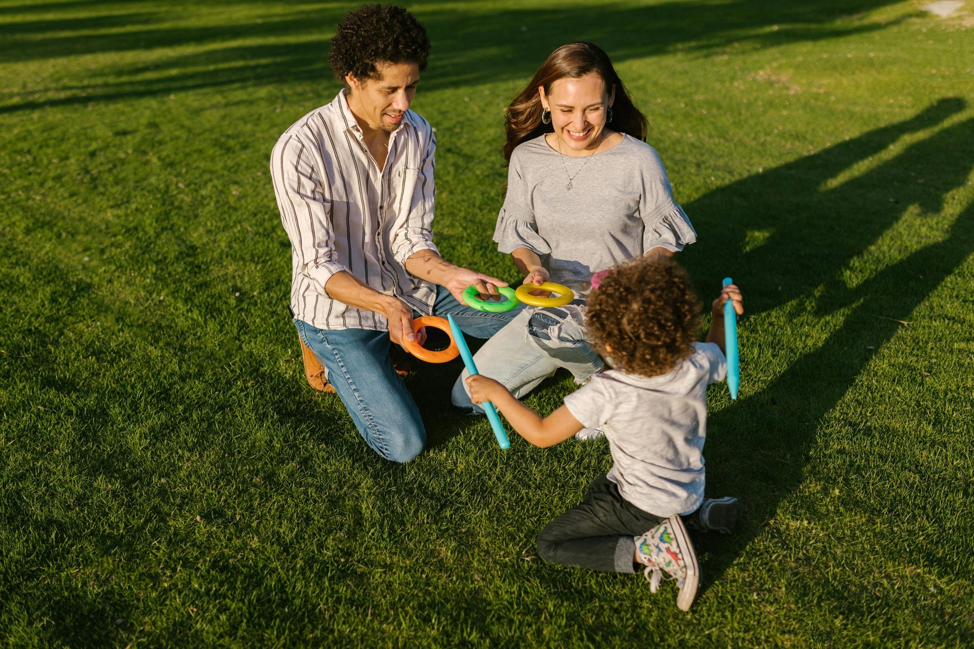 A family is playing with rings in a park.