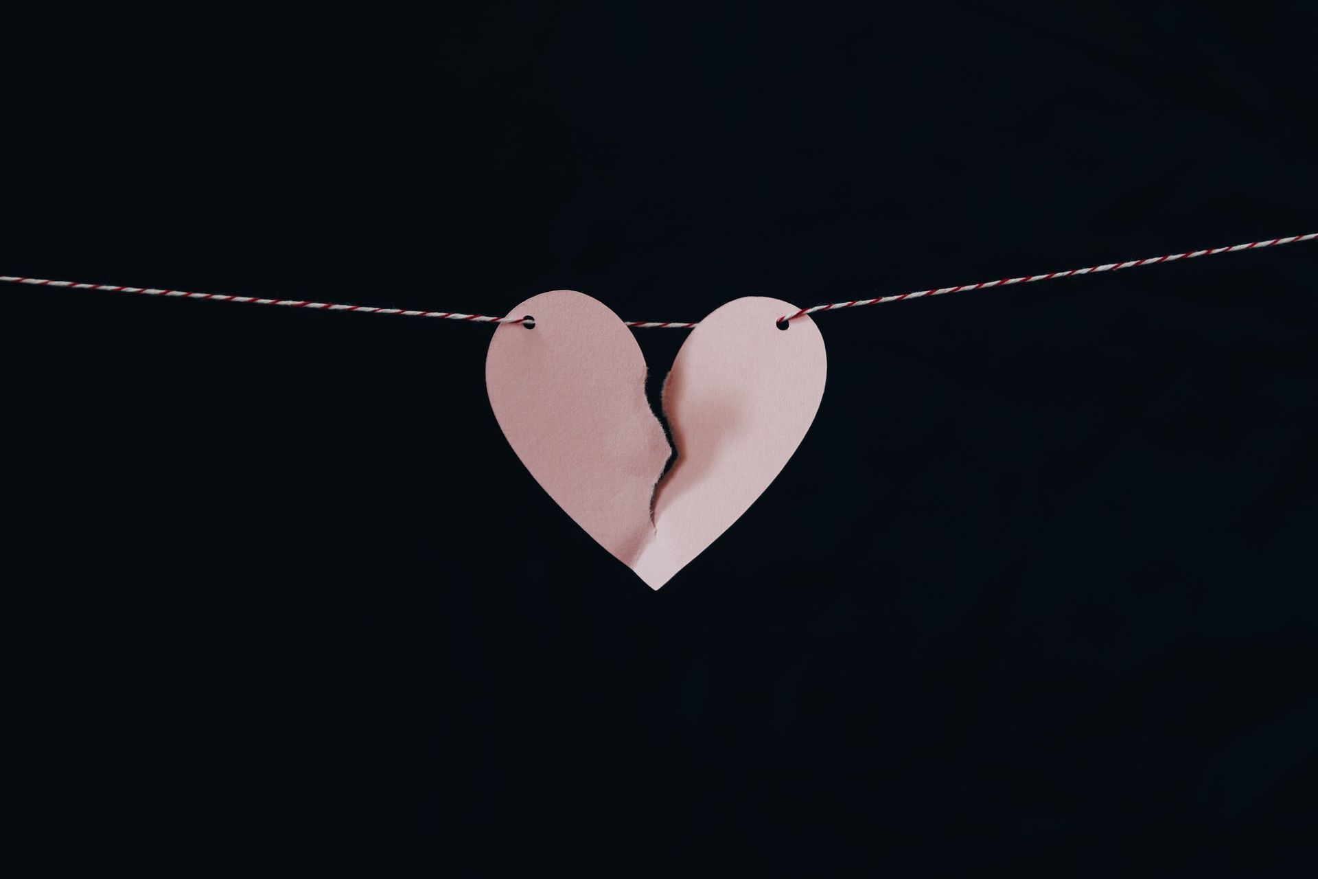 A broken heart is hanging on a wire.