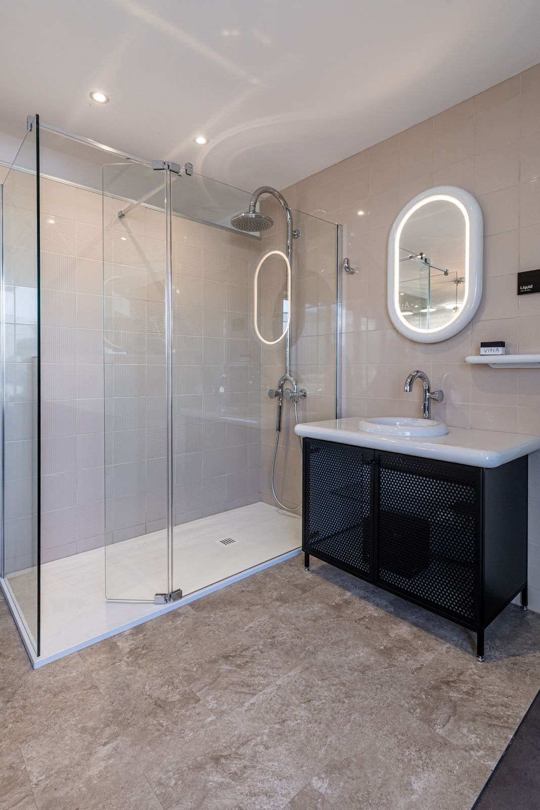 A bathroom with a walk in shower , sink and mirror.