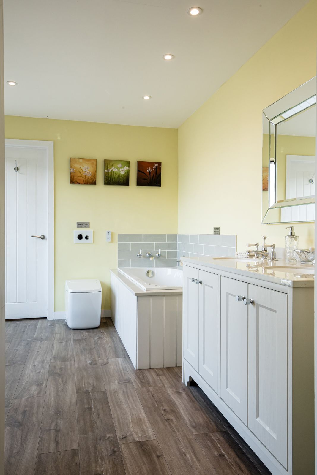 A bathroom with a bathtub , sink , toilet and mirror.