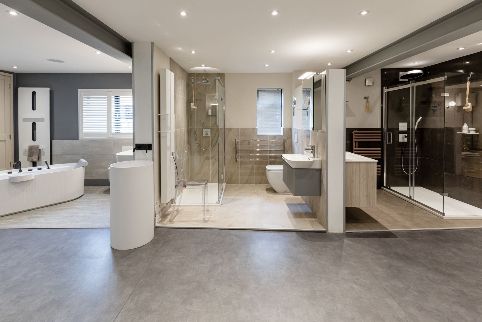 A bathroom showroom with a bathtub , sink , toilet and shower.