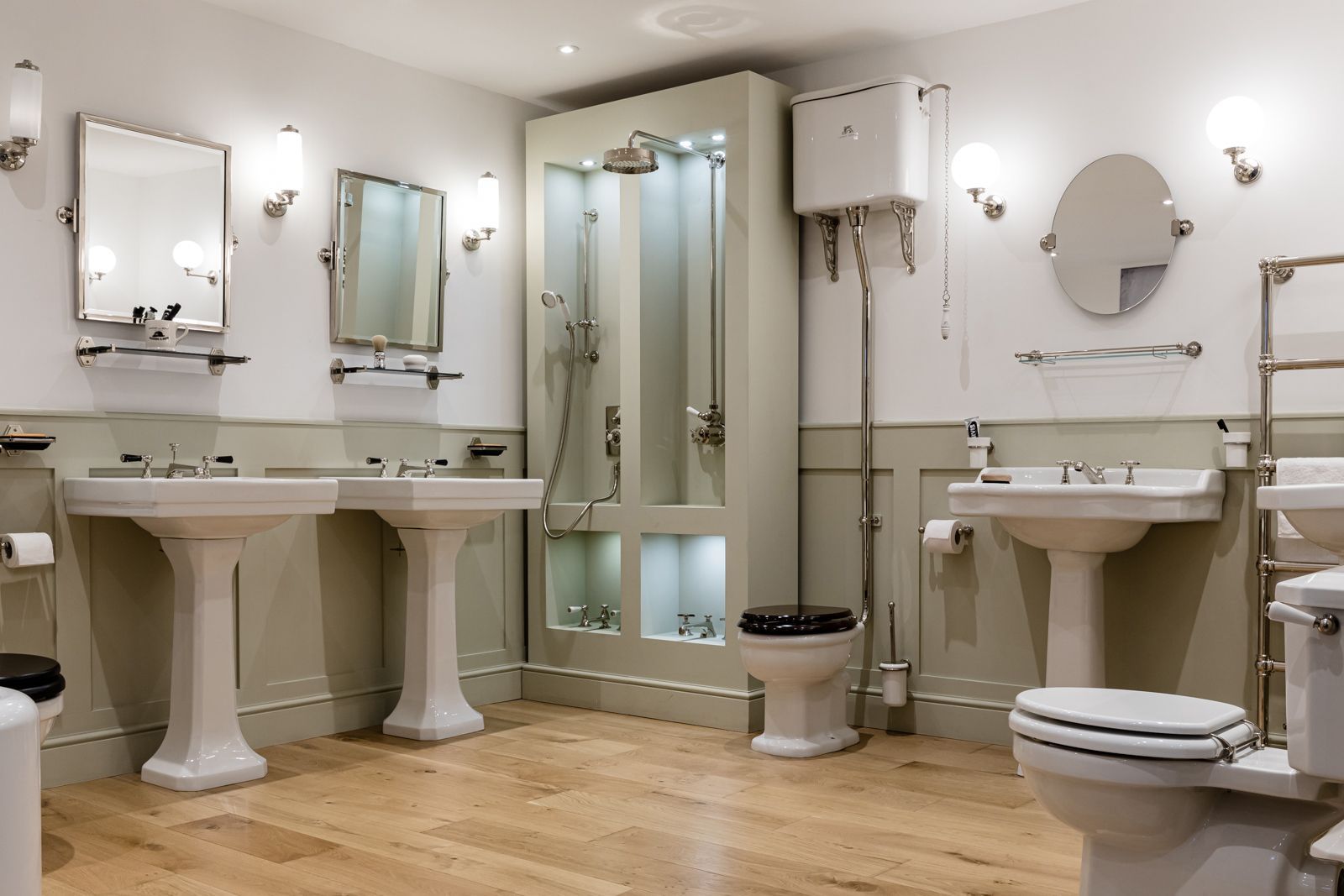 A bathroom with two sinks , two toilets , and a shower.