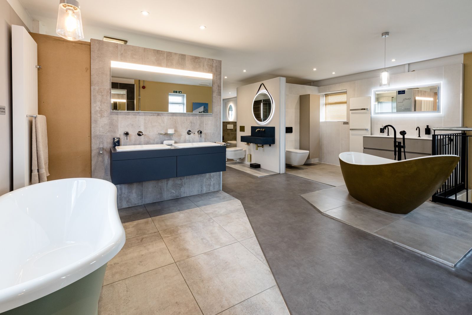 A bathroom with a bathtub , sinks , toilets and mirrors.