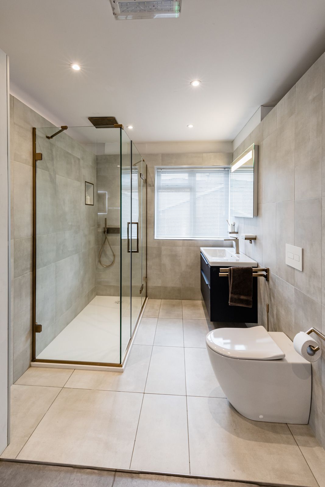 A bathroom with a toilet , sink and walk in shower.