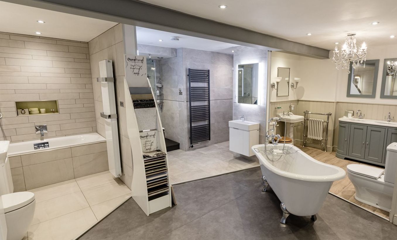 A bathroom with a bathtub , sinks , toilets and mirrors.