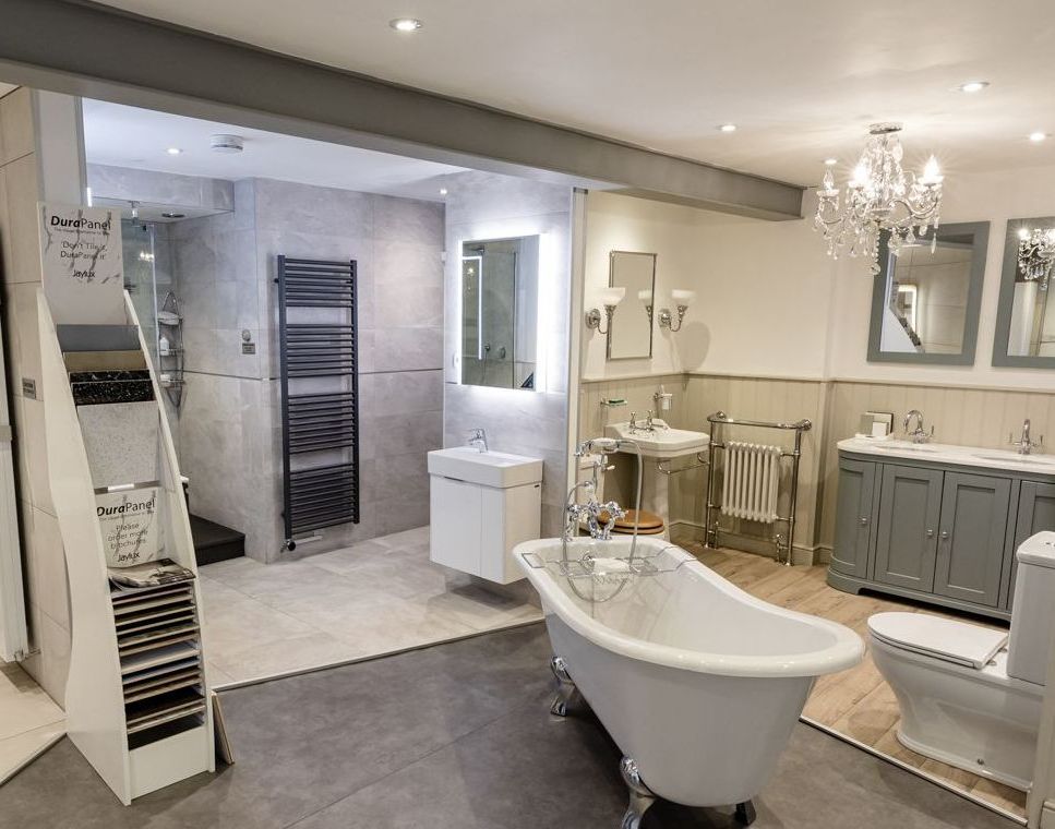 A bathroom with a bathtub , sink , toilet and mirrors.