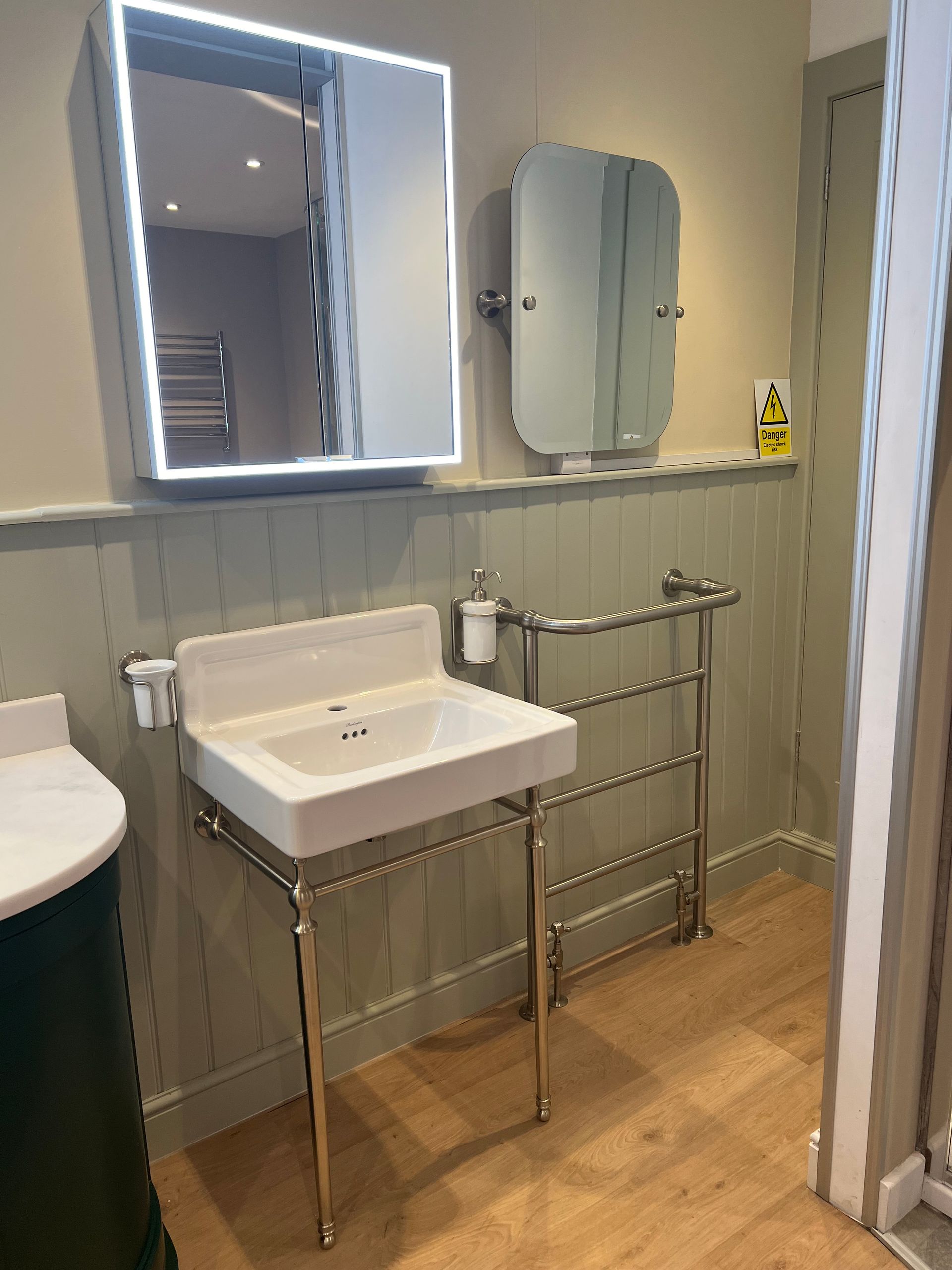 A bathroom with a sink , mirror and towel rack.