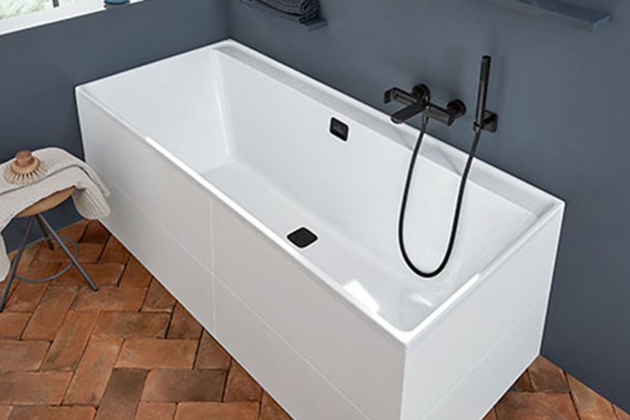 A white bathtub with a black shower head is in a bathroom.