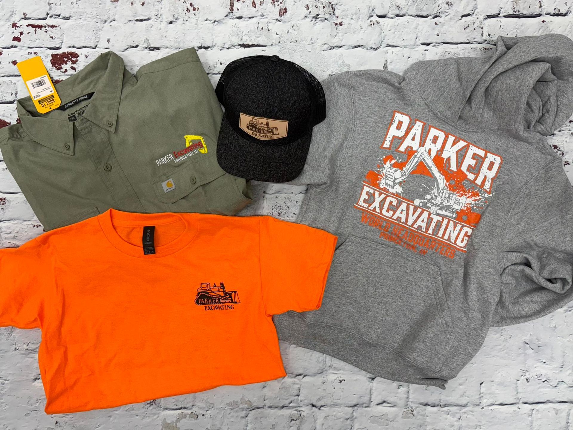 A group of shirts and hats are sitting on top of each other on a table. - Princeton, IN - Make Your Mark