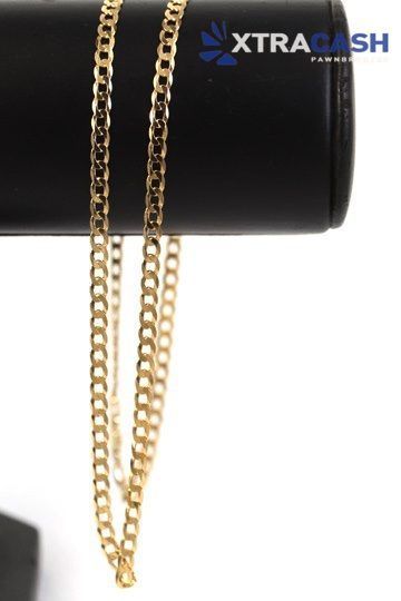 Gold chain necklace on a white background with a small clasp at the bottom right