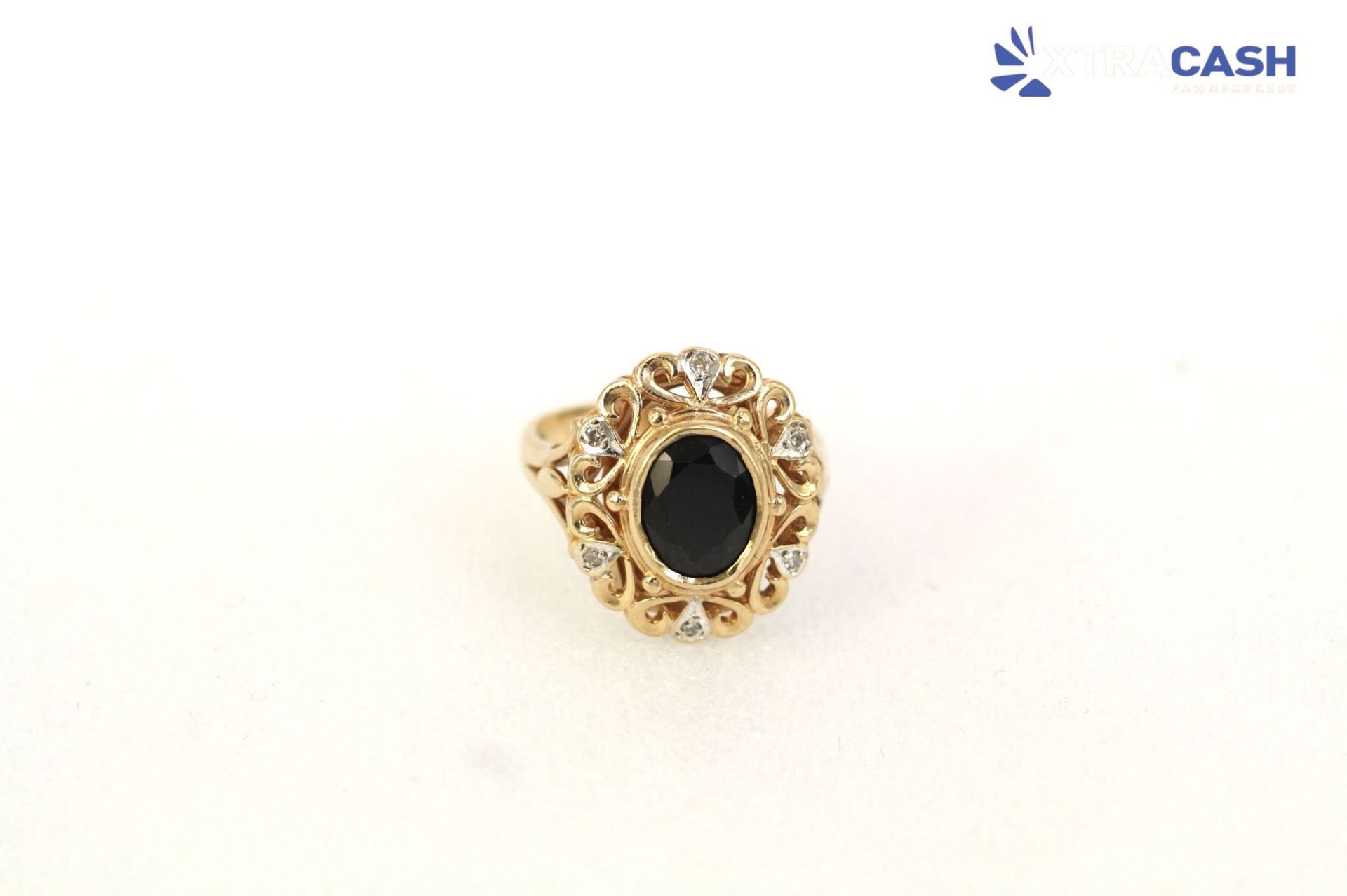 Gold ring with a black oval gemstone on a white background