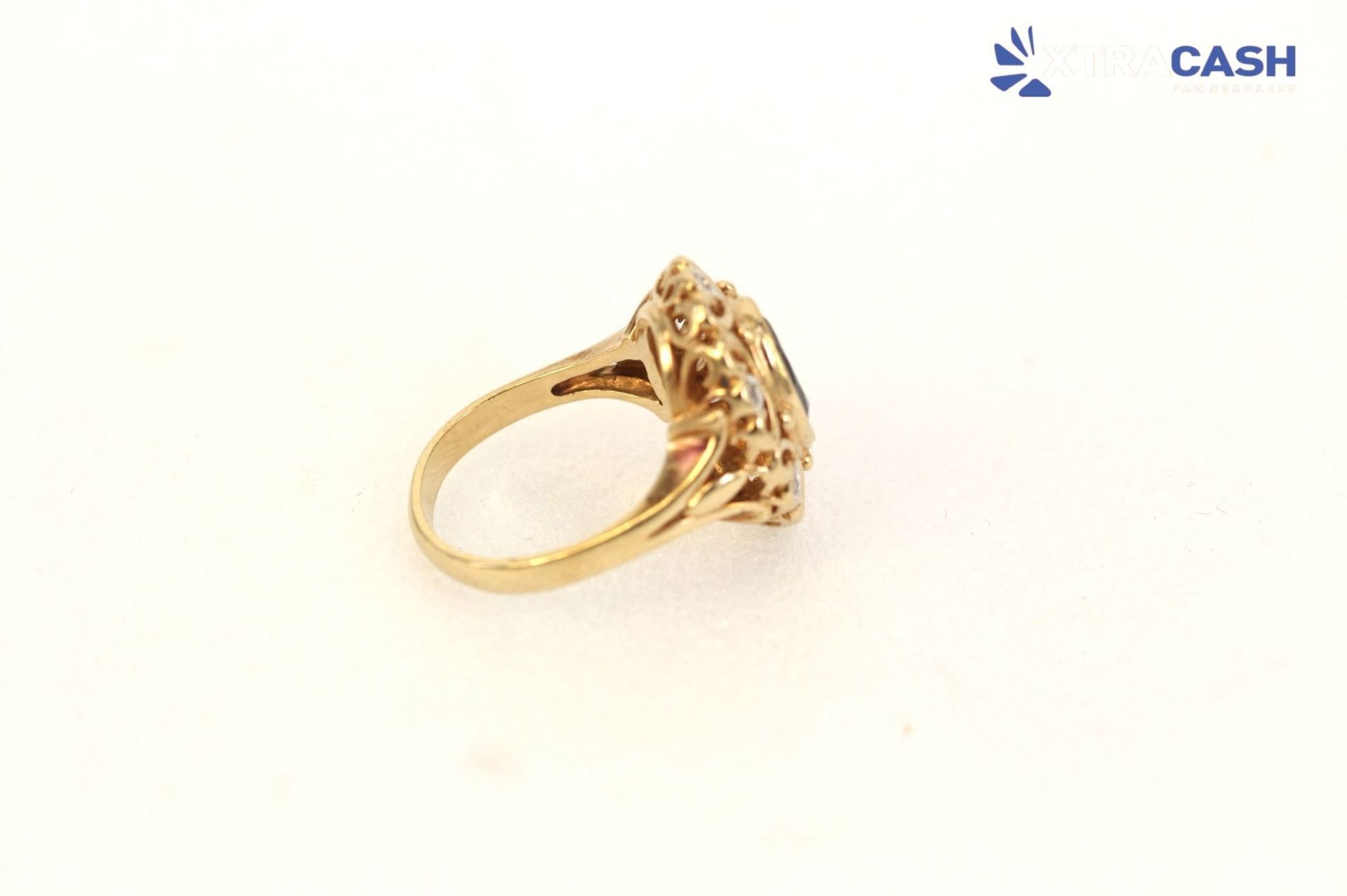 Gold ring with a black oval gemstone on a white background