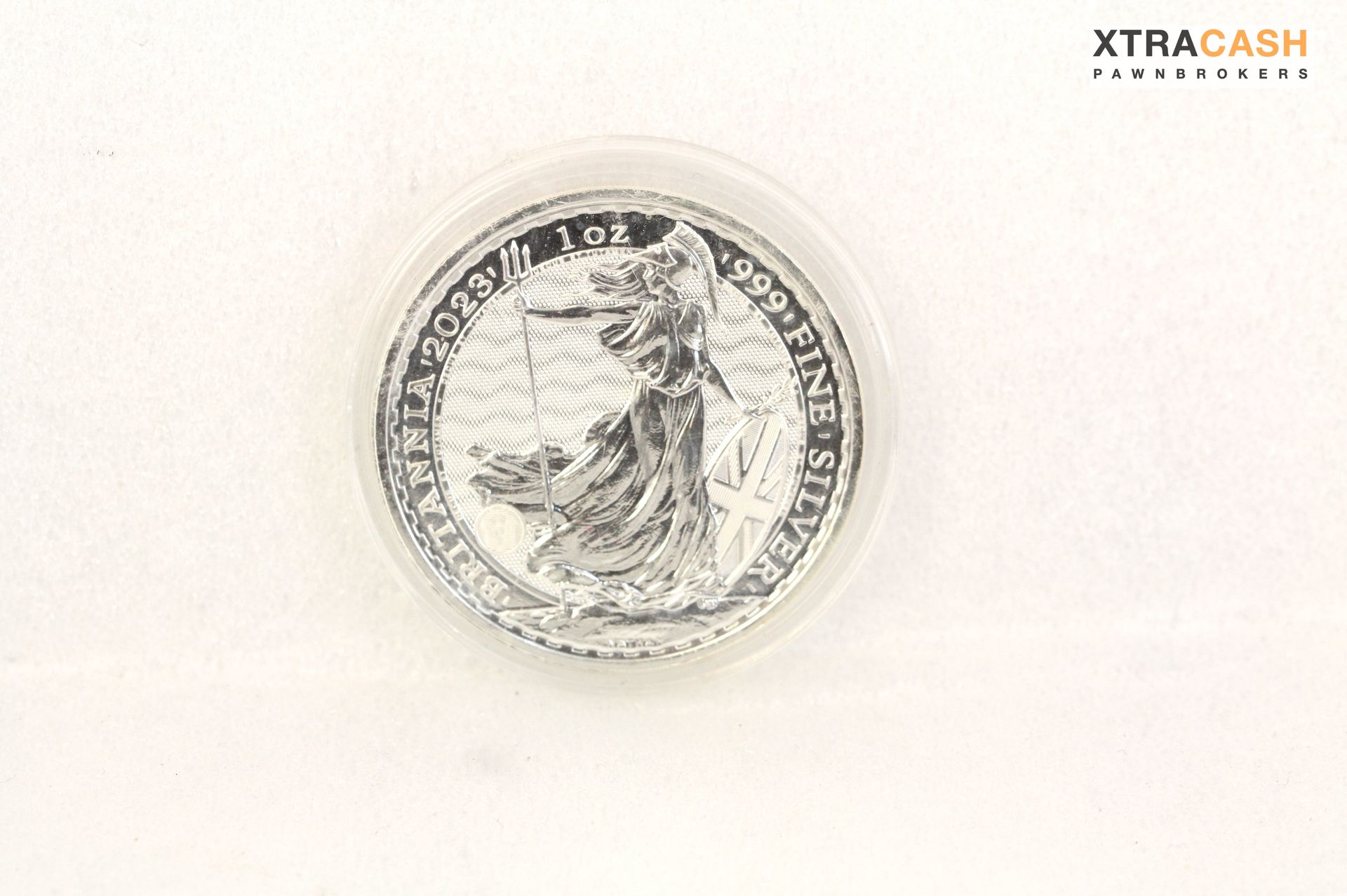 Silver coin on a white background with a circular emblem in the center