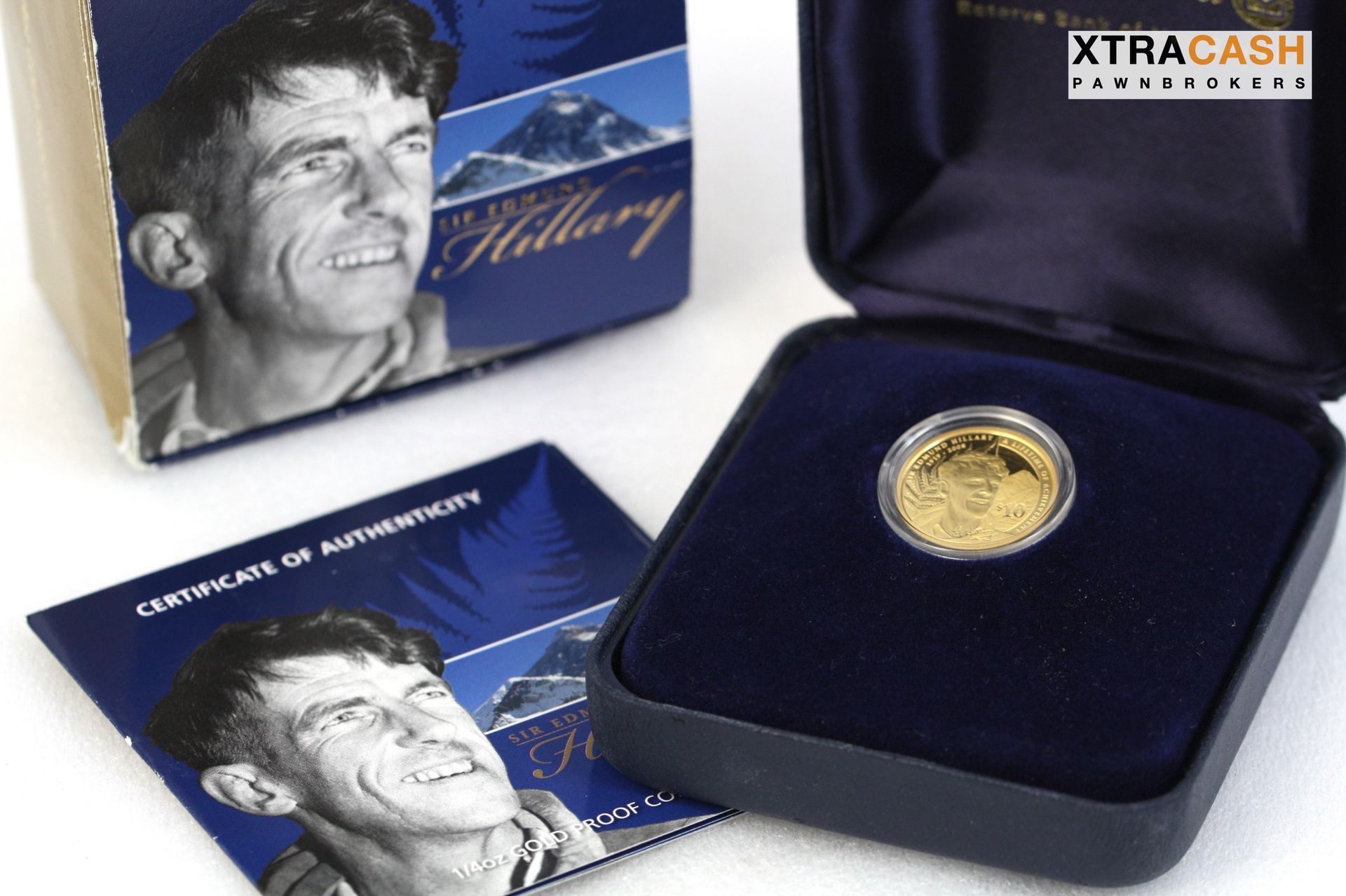 Blue commemorative coin set with a gold medallion in a velvet case and matching box on a white surface