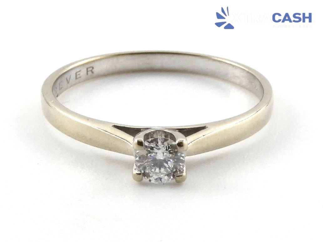 Silver ring with a small square diamond solitaire on a white background