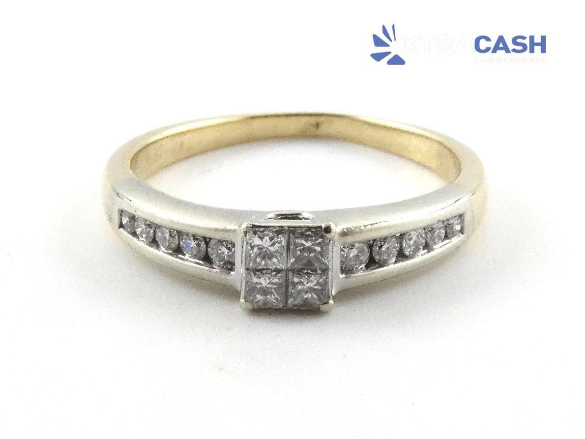 Gold ring with square center stone and small side stones on white background