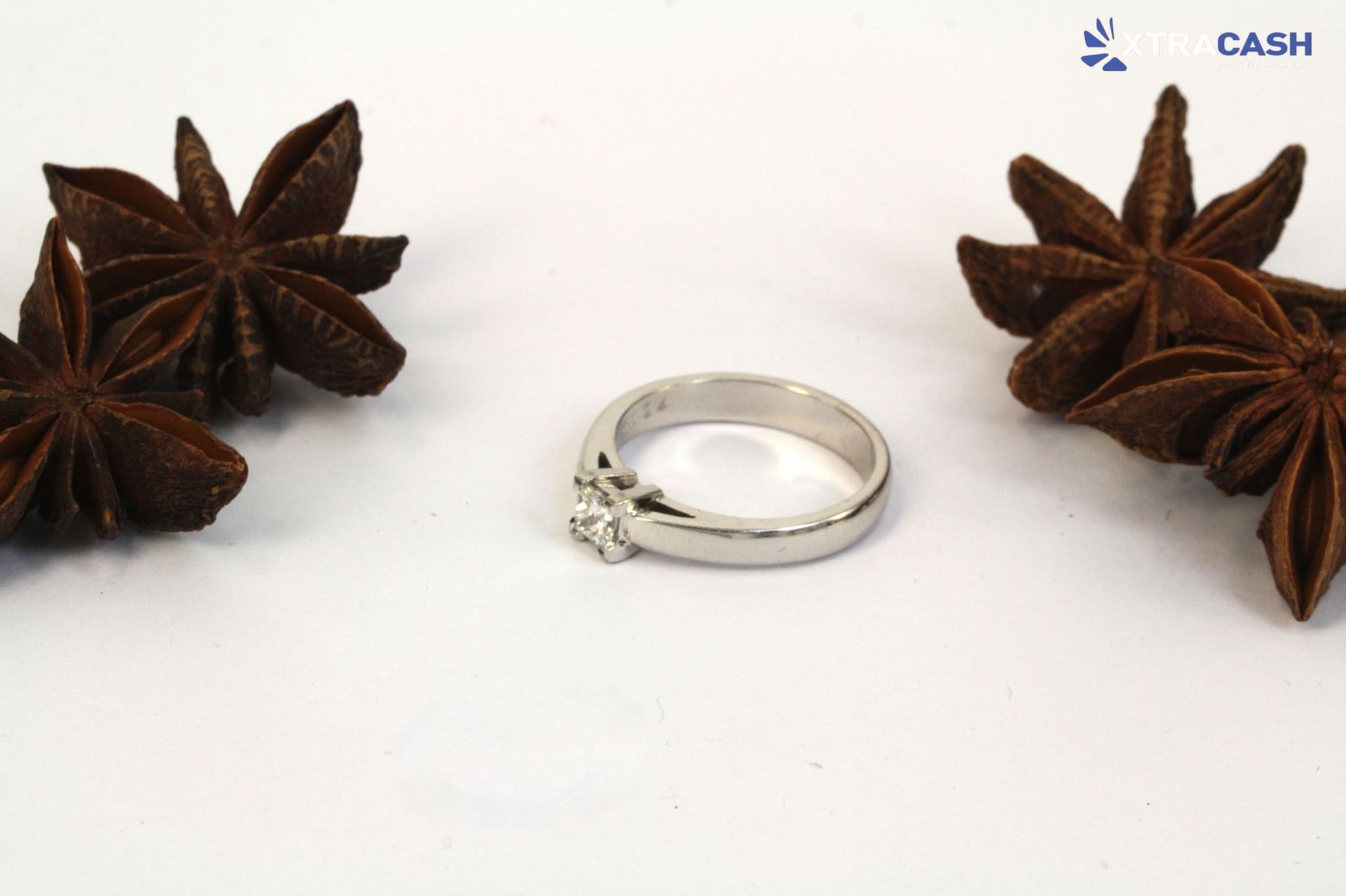 Silver ring with a square-cut clear gemstone on a white background