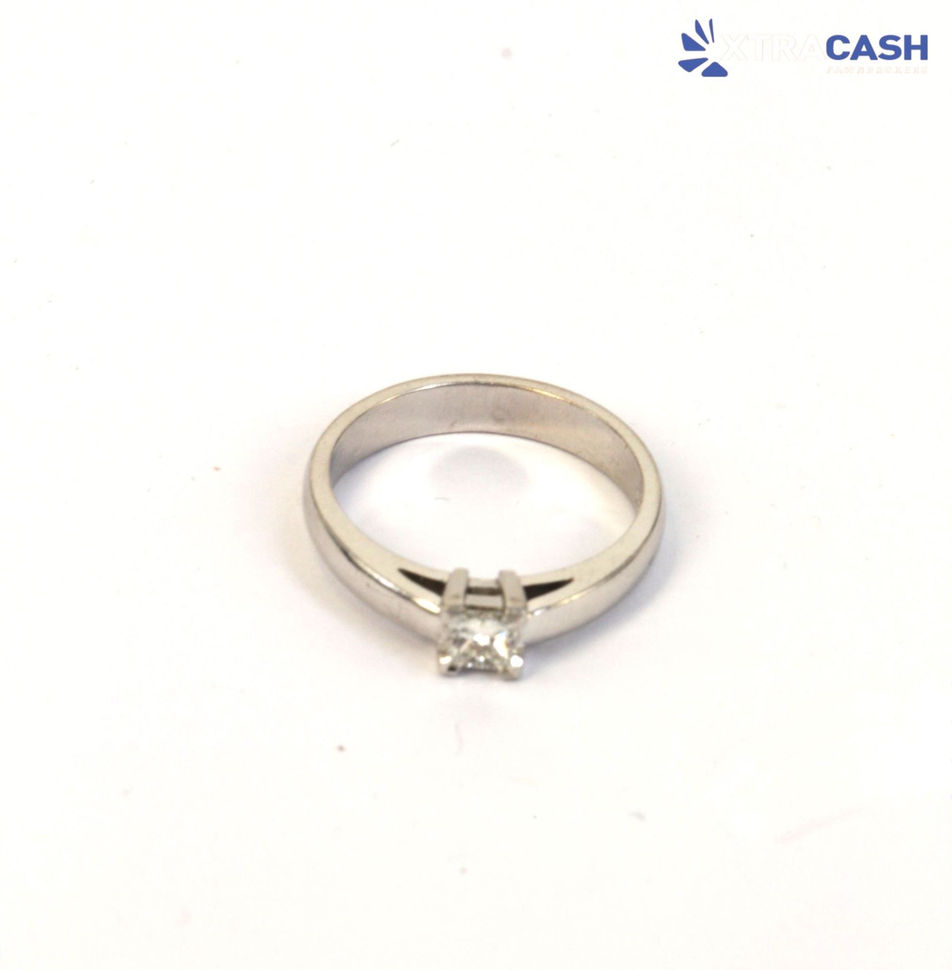 Silver ring with a square-cut clear gemstone on a white background