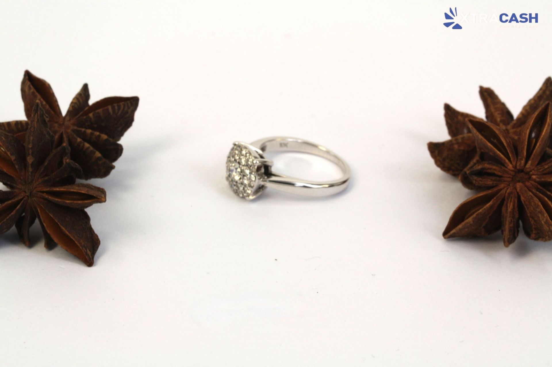 Silver ring with a cluster of clear stones on a white background