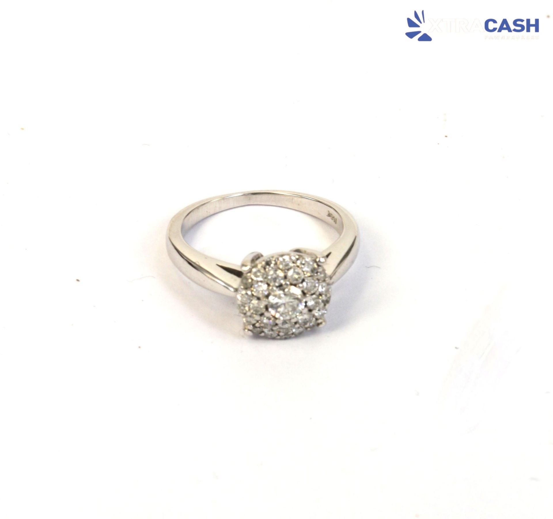 Silver ring with a round cluster of clear stones on a white background