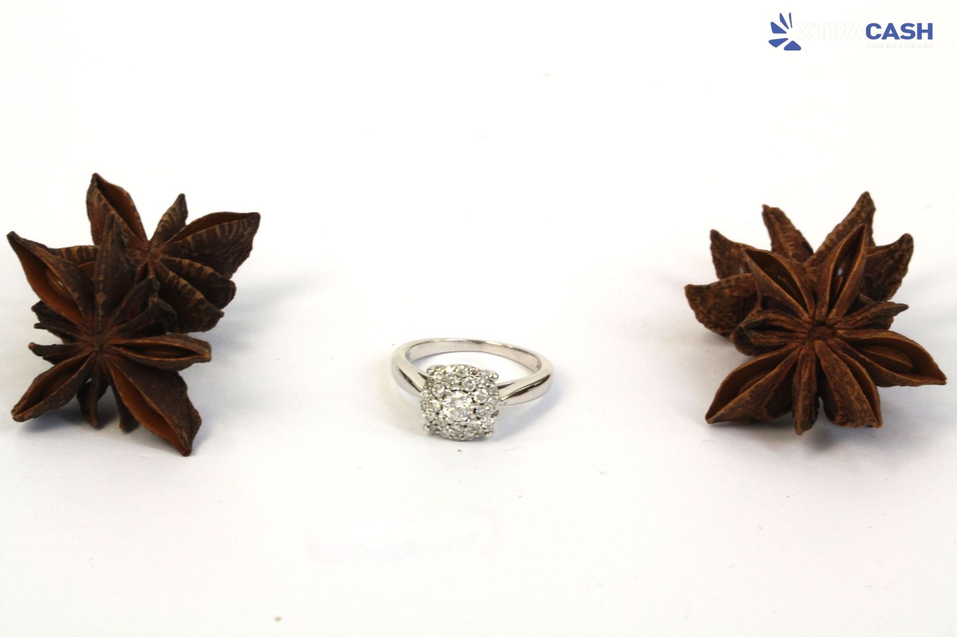 Silver ring with a round cluster of clear stones on a white background