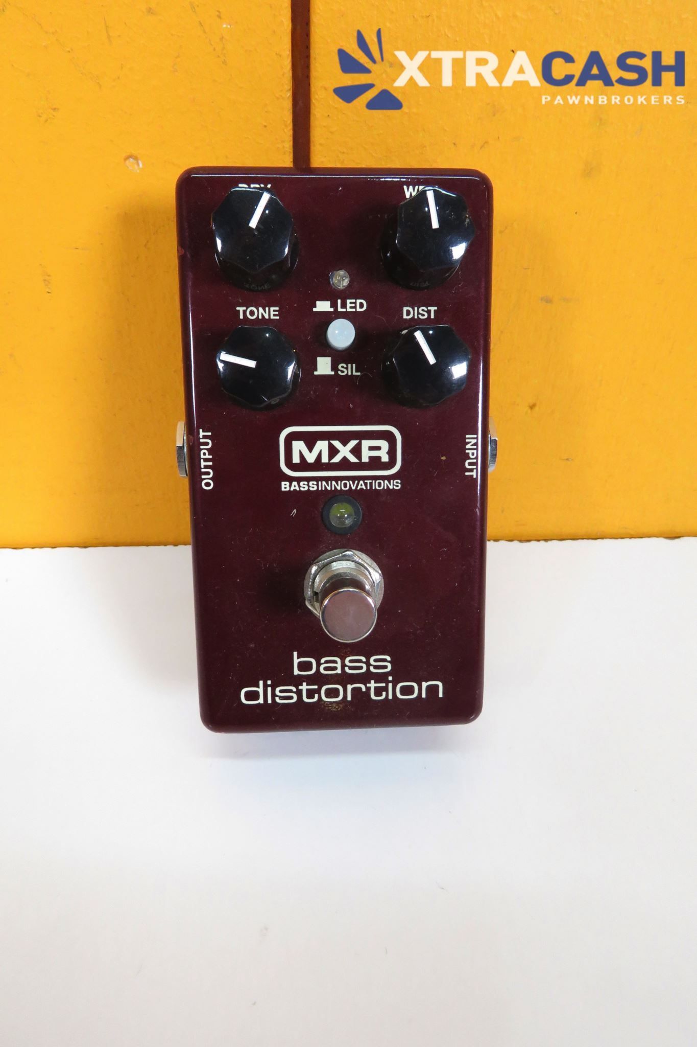Black MXR bass distortion pedal on a yellow XTRACASH box background