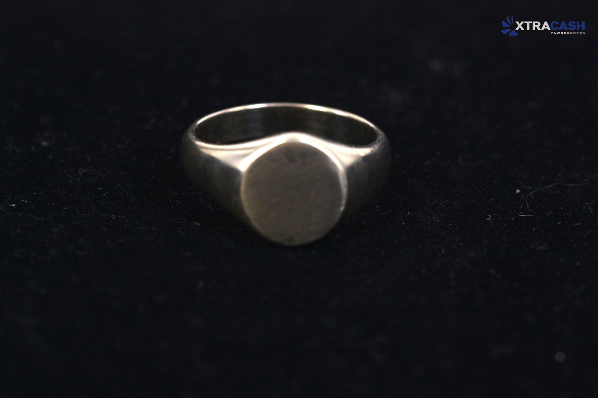 Silver ring with a round bezel on a black background