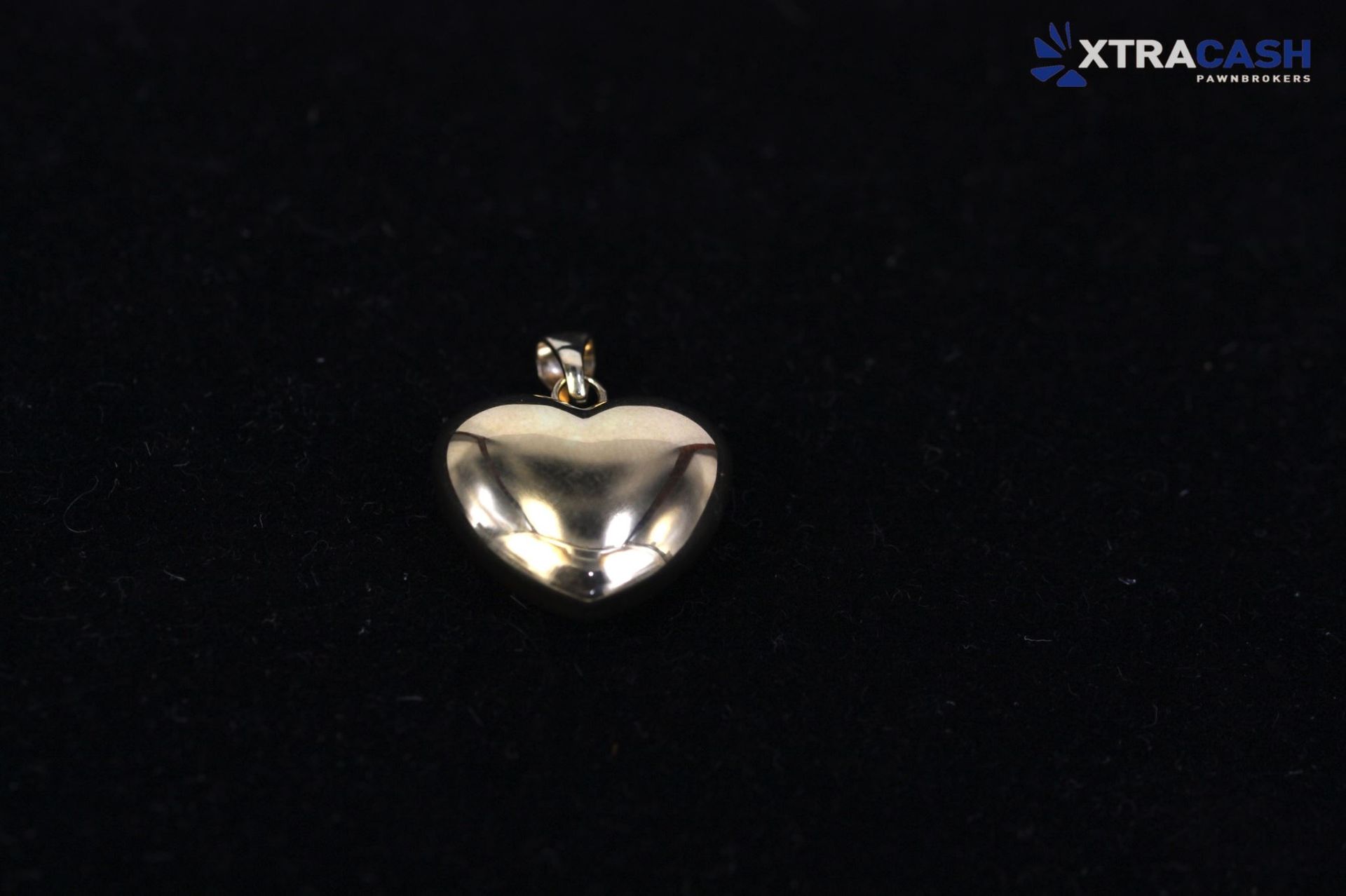 Small shiny silver pendant on a black background