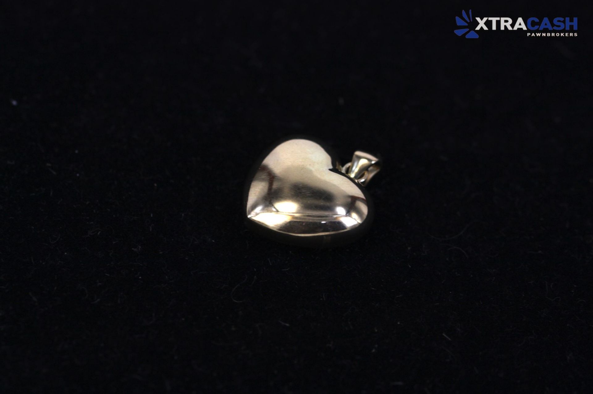 Small shiny silver pendant on a black background