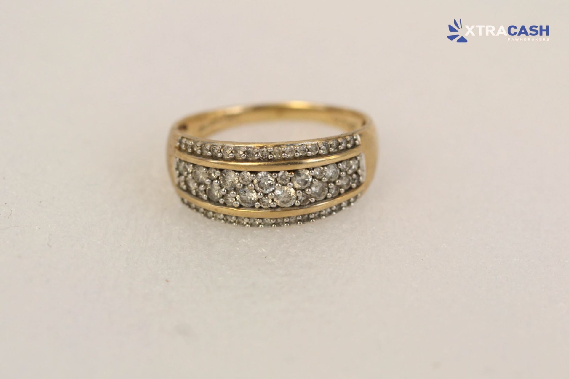Gold ring with diamond accents displayed in a white jewelry box