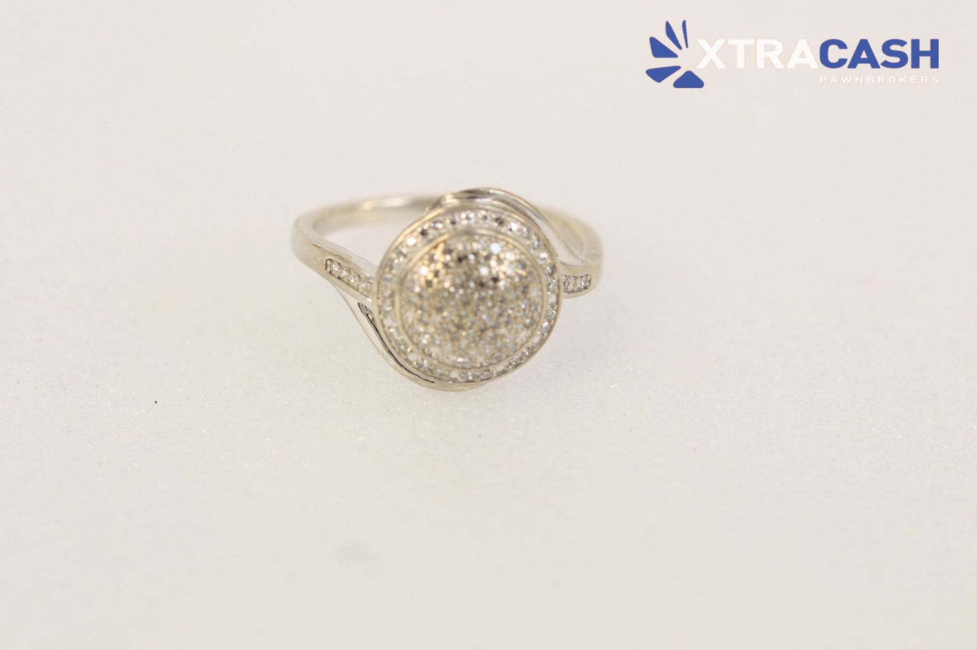 Silver ring with a round textured stone on a light background