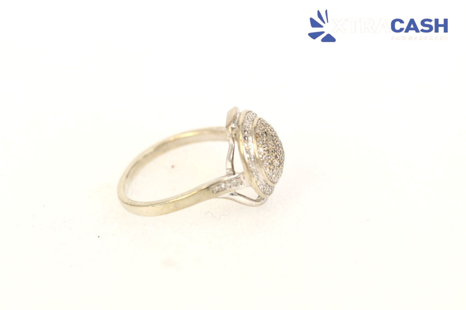 Silver ring with a round textured stone on a light background