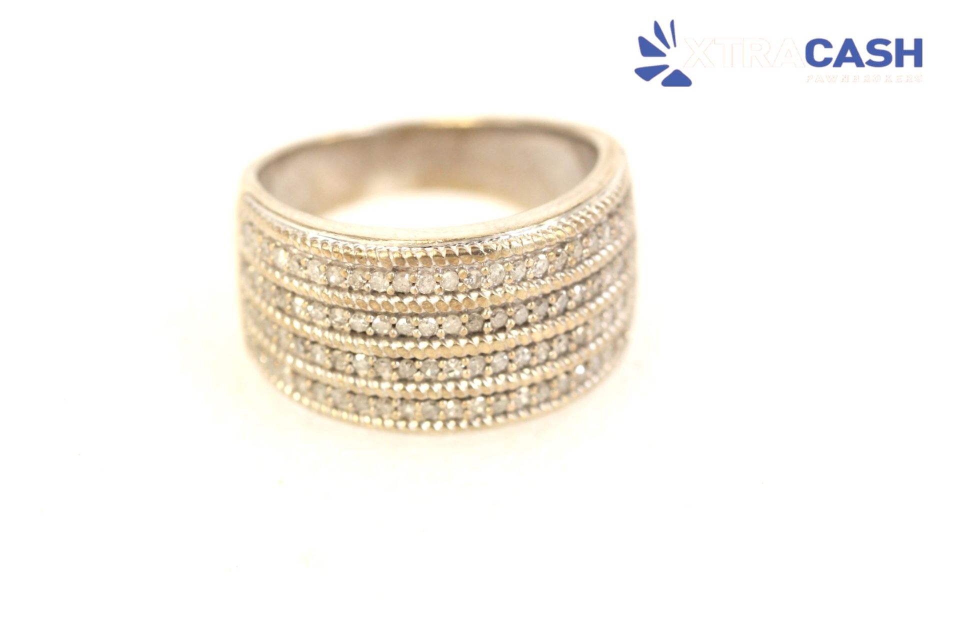 Gold multi-row diamond ring on a white background with a small CASH logo in the corner