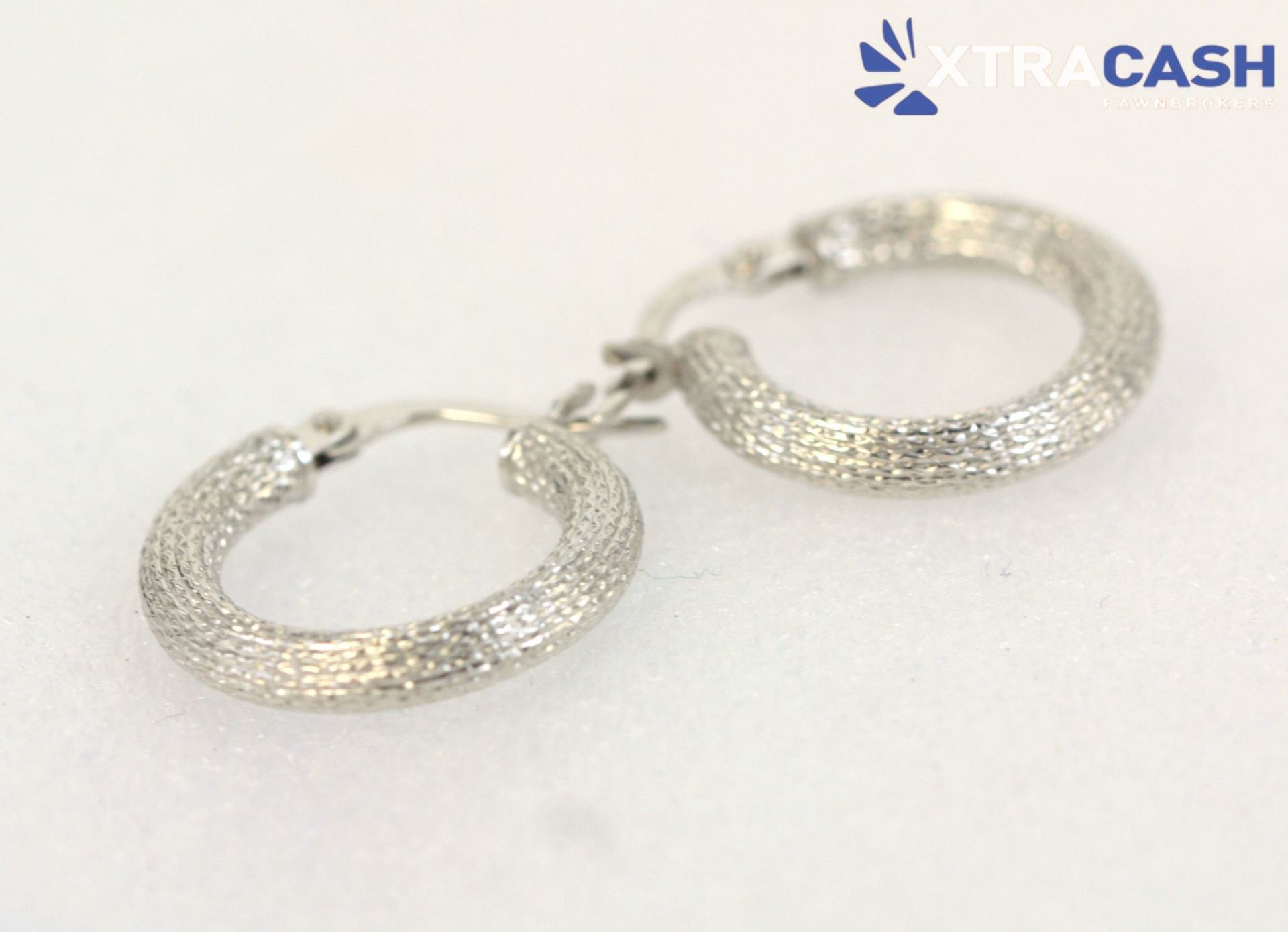 Two silver hoop earrings on a white background