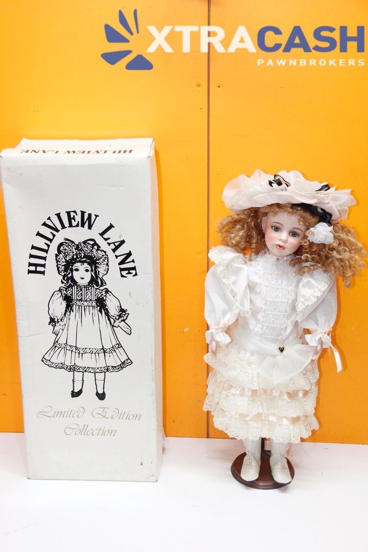 Vintage doll beside Halloween-themed box on orange and white display background