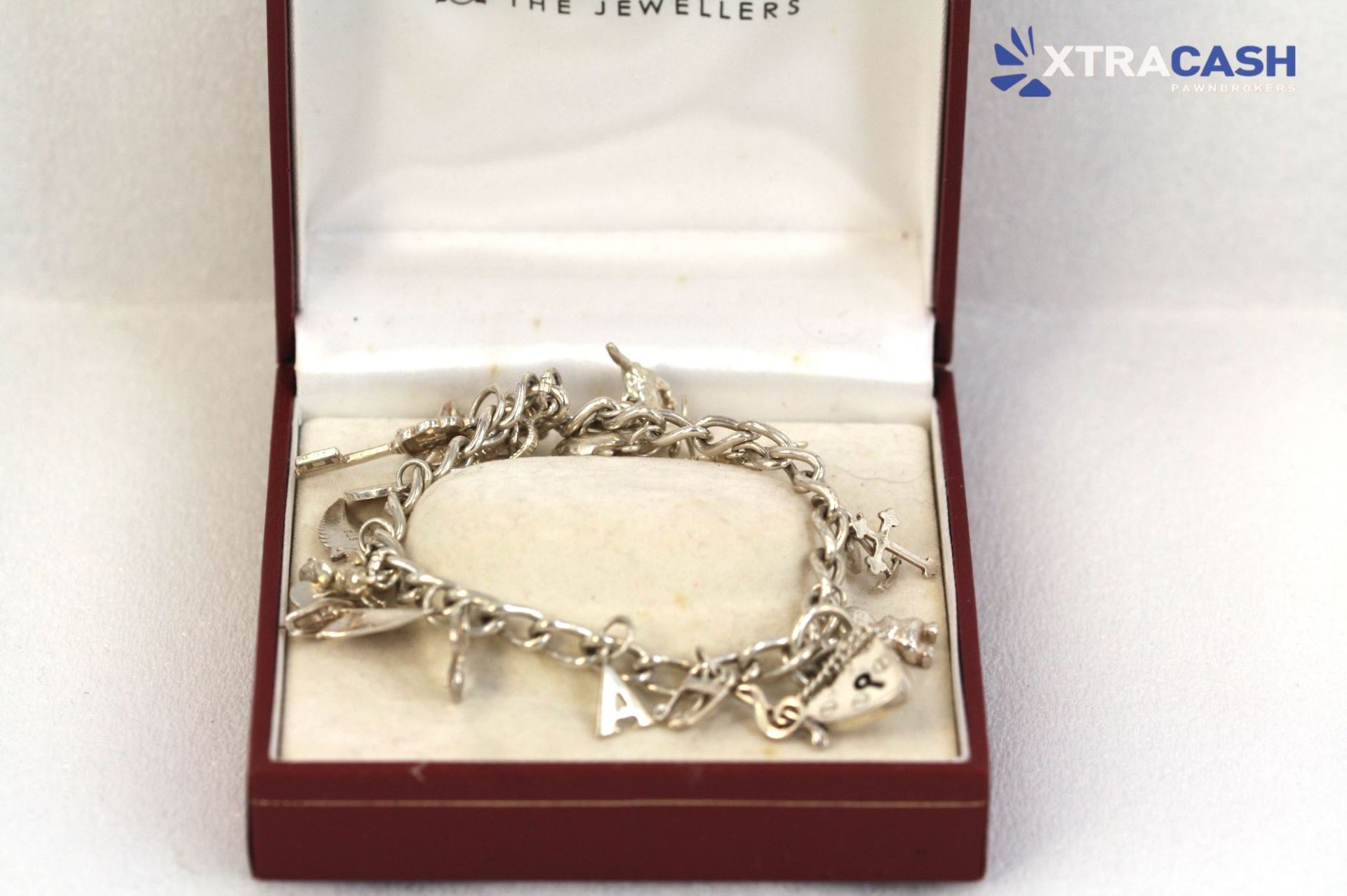 Silver chain bracelet in a red jewelry box on a white background.