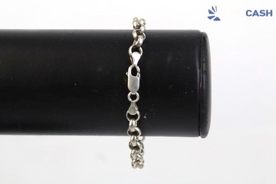 Silver chain bracelet draped over a black cylindrical display stand on a white background