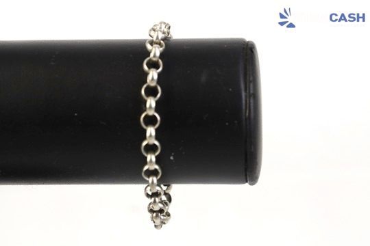 Silver chain bracelet draped over a black cylindrical display stand on a white background