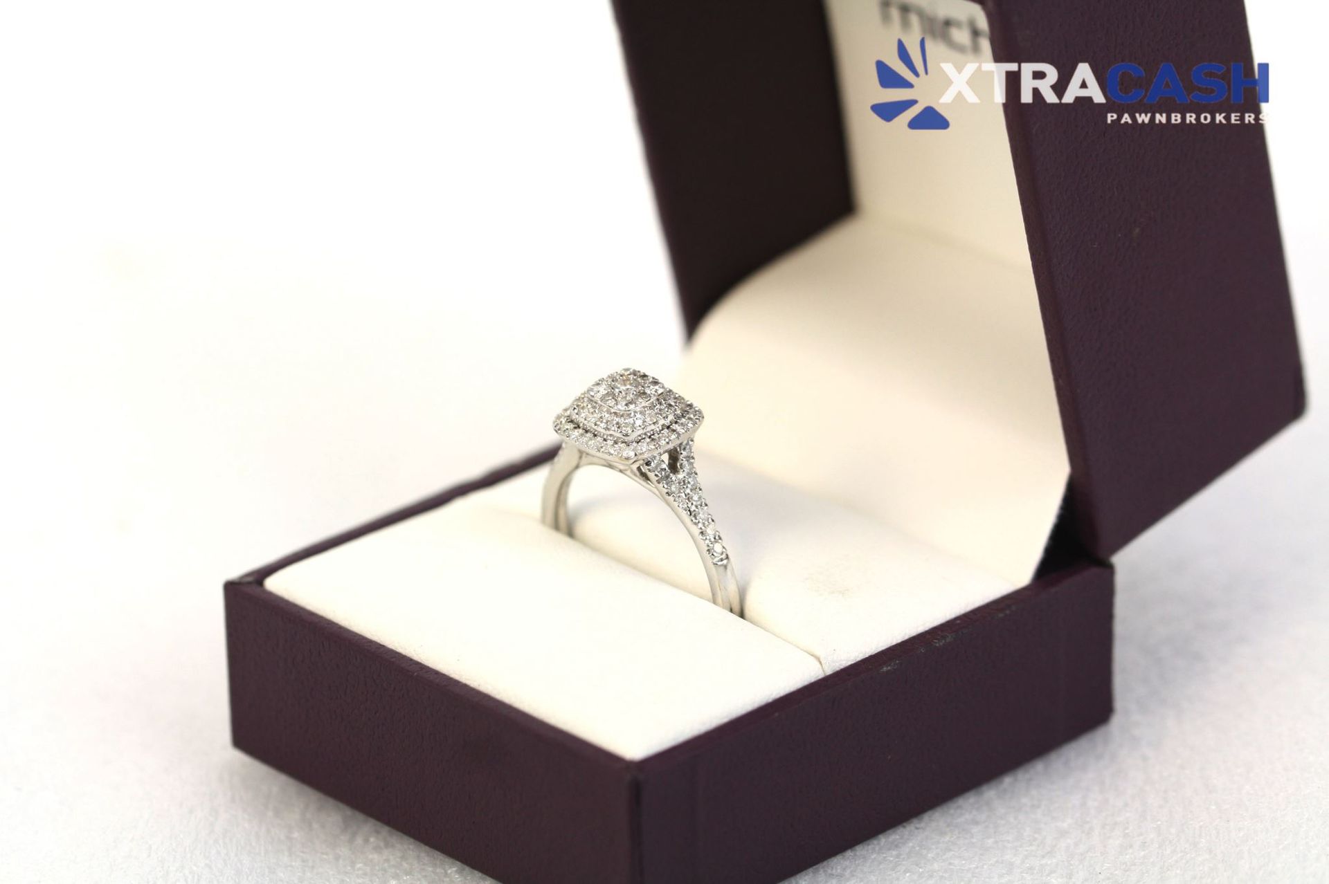Diamond ring in an open purple jewelry box on a white background