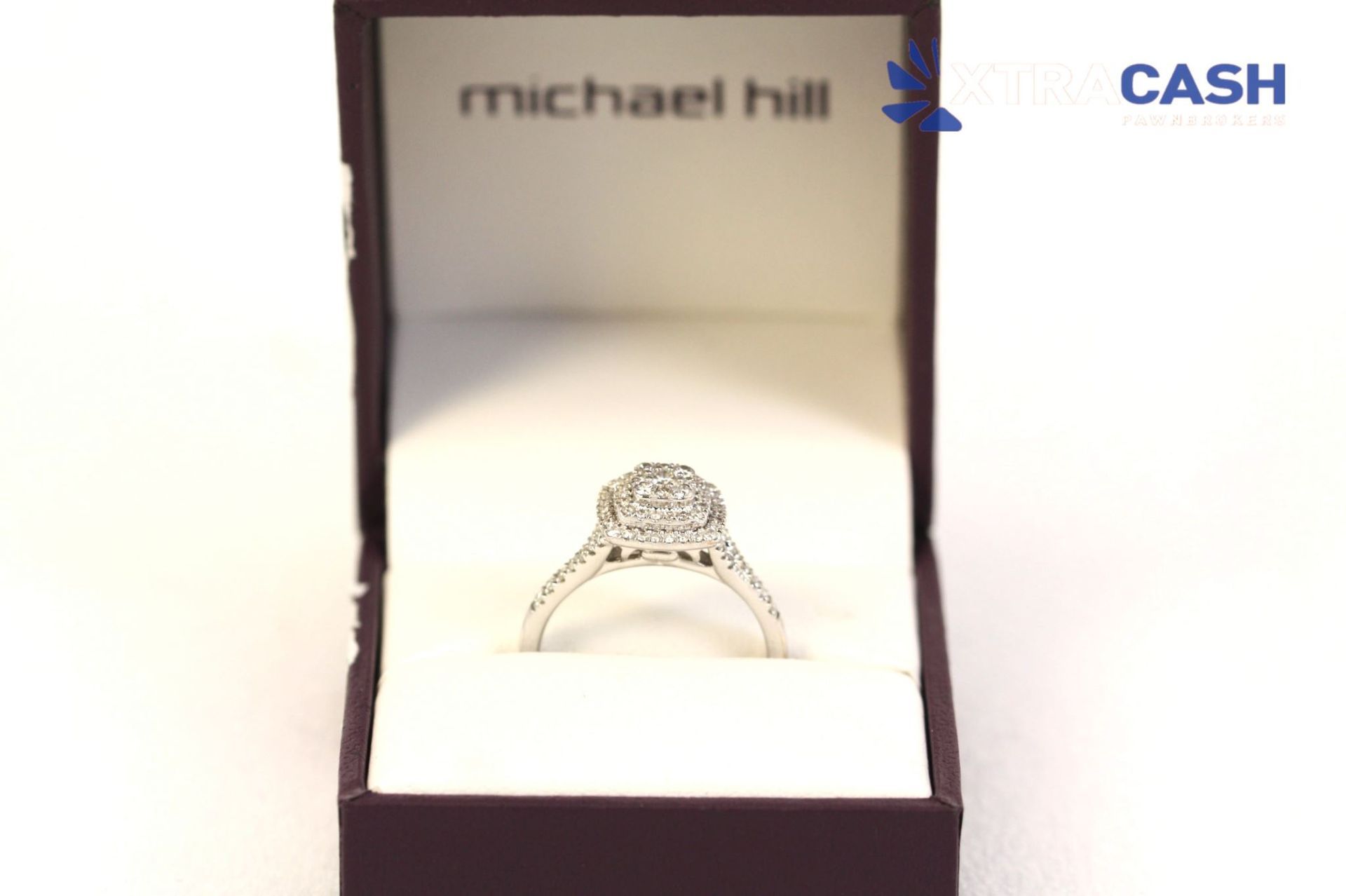 Diamond ring in an open purple jewelry box on a white background