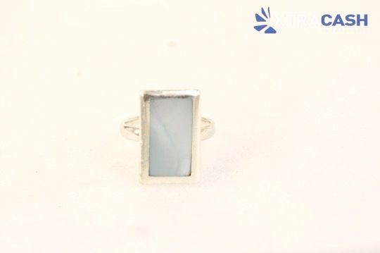 Small rectangular ring with a pale blue stone on a light background, labeled “CASH” in the corner