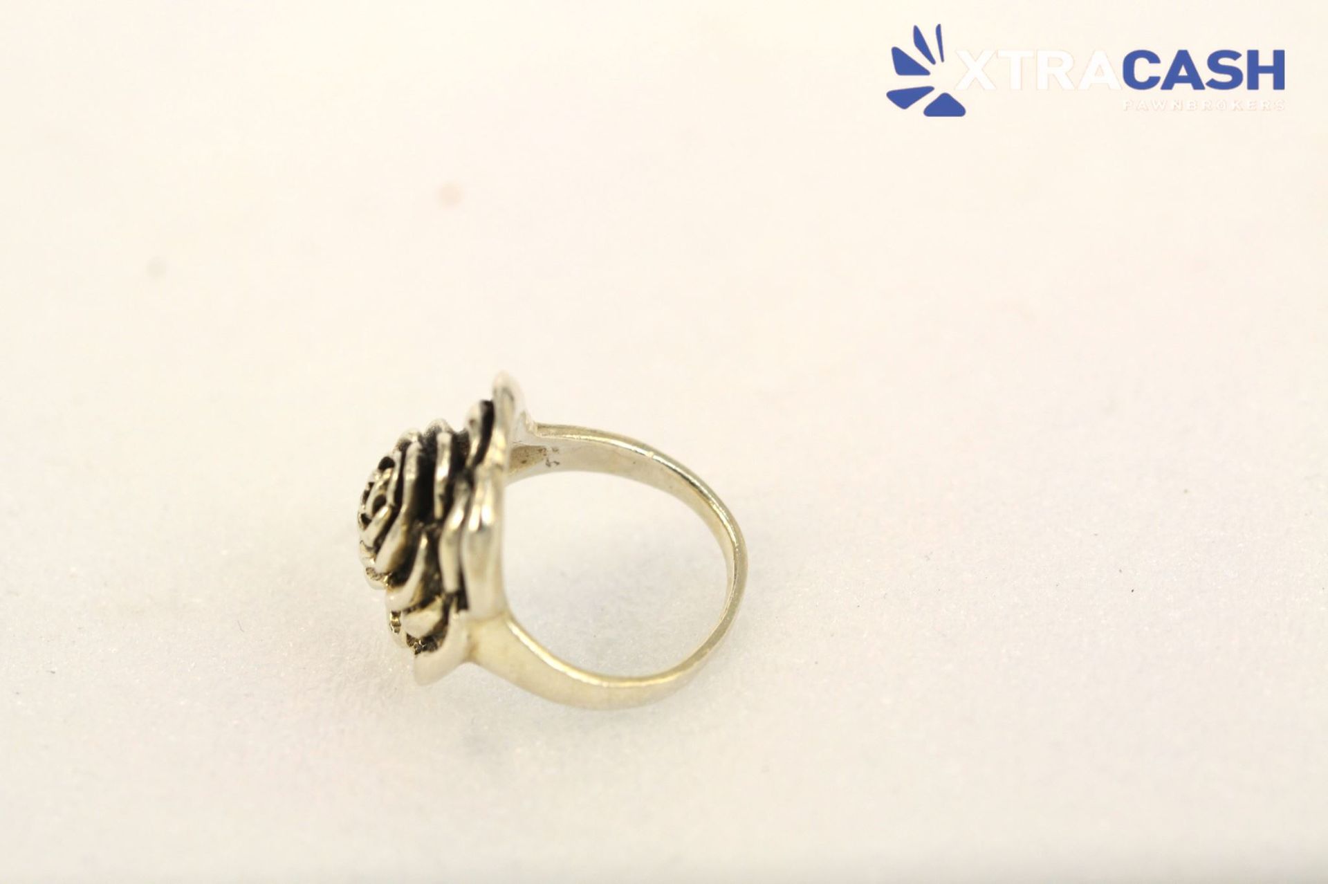 Silver floral ring with a black-stone rose design on a light background