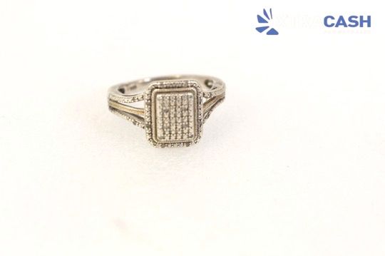 Gold ring with rectangular diamond-like center on a white background, labeled “CASH” in the top right.