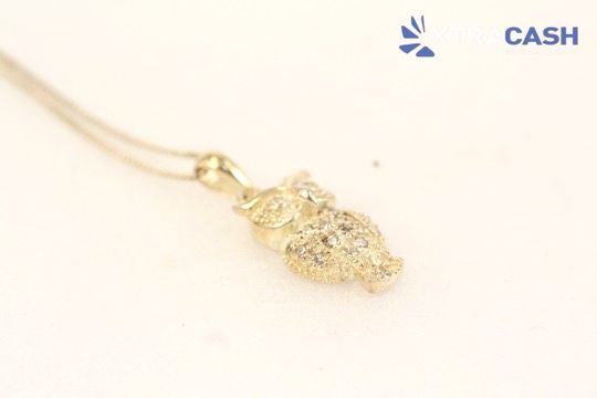 Gold pendant necklace on a light background with a small CASH logo in the corner