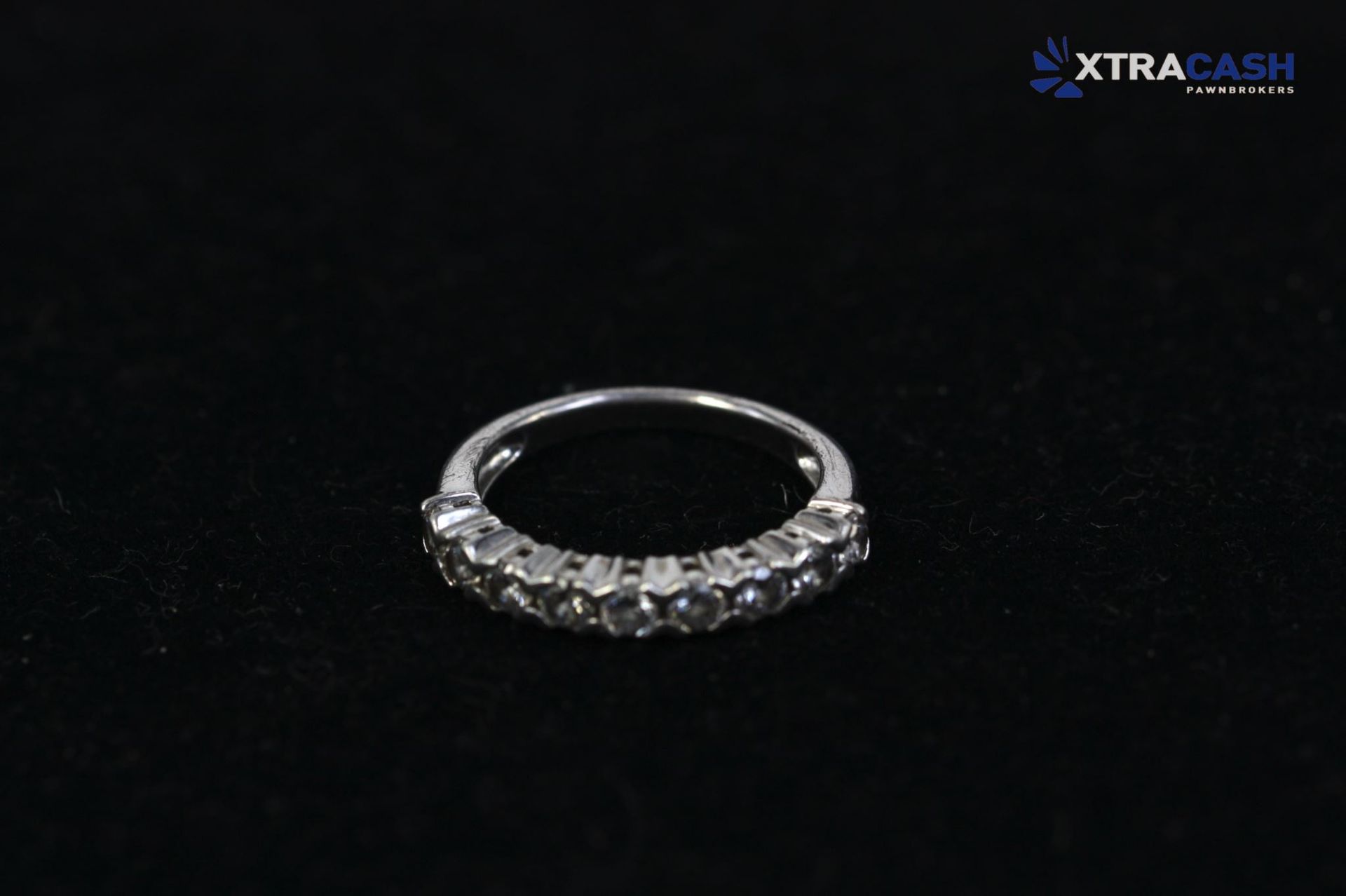 Silver ring with clear gemstones on a black background